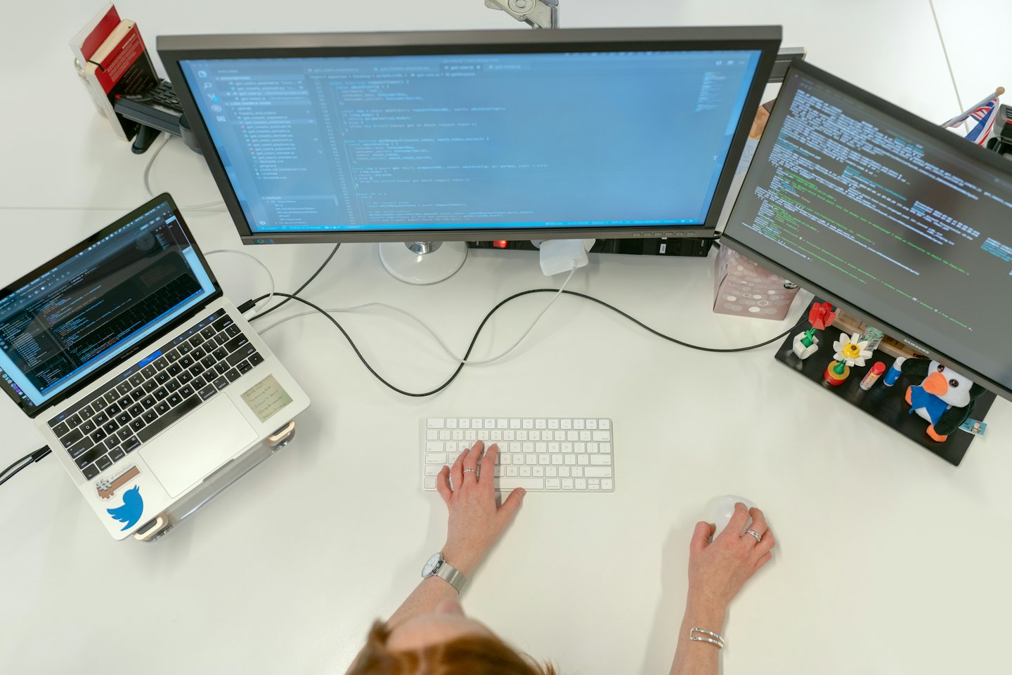 Developer coding on a multi-monitor workstation in an office.