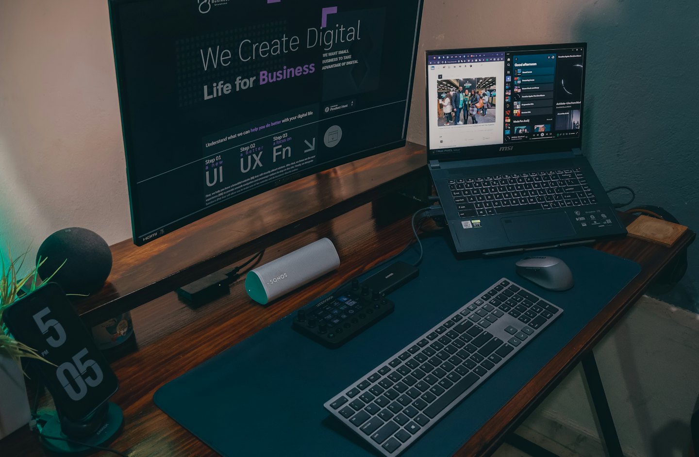 Laptop and monitor displaying digital content on a wooden desk.